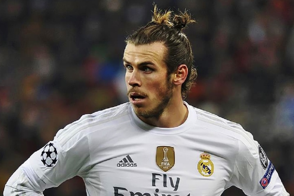 An employee displays new Gareth Bale Real Madrid shirts at the